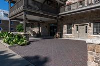 a walkway leading to the front door of a home with some landscaping around it, and two balconies in the background