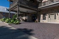 a walkway leading to the front door of a home with some landscaping around it, and two balconies in the background