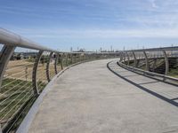 a walkway with two bikes going through it near the water and a dock on a pier