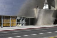 an architectural structure is shown on a side walk, in front of a building with silver facade