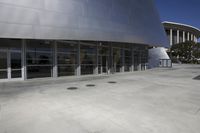 empty parking lot outside of building with multiple open windows with large steel panels behind door