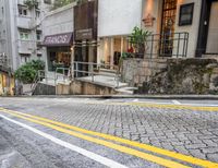 a city street has an empty white bus stop sign in the middle of it and a stone road