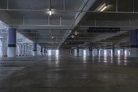 there are only two car park spaces in this warehouse building with concrete flooring and large, blue columns