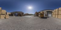 the view is taken through a fish eye lens while several boxes sit in a warehouse yard