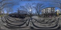 a fish eye lens photo of a street with a motorcycle and car parked at the curb