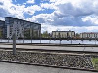 a person is walking along tracks next to the water and some buildings with large windows