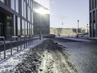 a car parked in the middle of the road near large buildings with snow on them