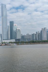 a big building that is in the water near some buildings and skyscrapers above it