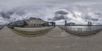 the spherical lens image shows clouds above buildings along a waterway with a view of buildings