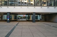 an entrance to a building in a city setting with two signs on the floor saying'welcome '