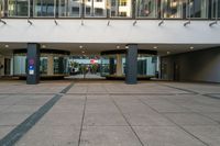 an entrance to a building in a city setting with two signs on the floor saying'welcome '