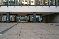 an entrance to a building in a city setting with two signs on the floor saying'welcome '