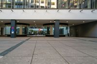 an entrance to a building in a city setting with two signs on the floor saying'welcome '