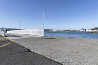 the boardwalk is leading towards the water to a pier next to some boats on the beach