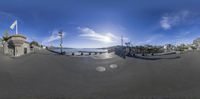 a fish - eye view shows a view of a lake from the sidewalk and a bridge