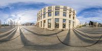 a wide angle fish eye view of a city street with circular buildings in the background