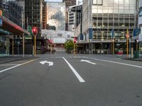 two arrows on a street with buildings in the background, and an empty street that is marked red, at one point