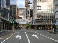 two arrows on a street with buildings in the background, and an empty street that is marked red, at one point