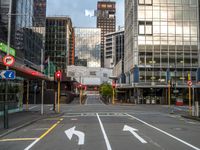 two arrows on a street with buildings in the background, and an empty street that is marked red, at one point