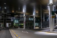 a street with a couple lights on in front of a building at night in the middle of town