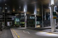 a street with a couple lights on in front of a building at night in the middle of town