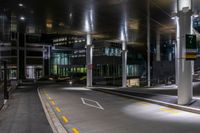 a street with a couple lights on in front of a building at night in the middle of town