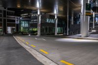 a street with a couple lights on in front of a building at night in the middle of town