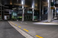 a street with a couple lights on in front of a building at night in the middle of town