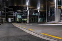 a street with a couple lights on in front of a building at night in the middle of town