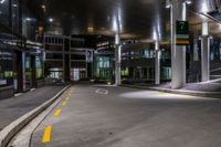 the empty building at night is lit up with lights and parking meters across the street