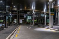 the empty building at night is lit up with lights and parking meters across the street