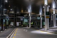 the empty building at night is lit up with lights and parking meters across the street