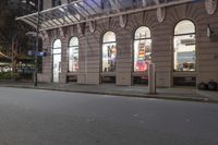 the corner of an empty building has windows lit with brightly lit lights on it's side