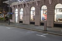 the corner of an empty building has windows lit with brightly lit lights on it's side