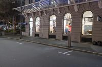 the corner of an empty building has windows lit with brightly lit lights on it's side