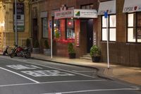 a street scene with motorcycle and stores on the sidewalk at night time, with no people