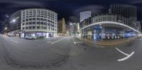 two fisheyes with a city background at night while looking through them of an intersection