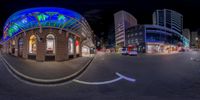 a fish eye view of a building on a busy street in a city at night