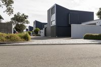 a street lined with residential houses on both sides of it and a blue garage with a white door