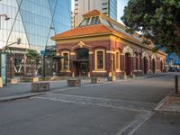 an older fashioned building has a orange roof and a yellow shin roof and pillars at the end of the street