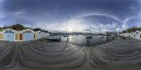 the sky is overcast and empty with small boats on the dock at a marina