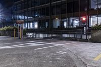 a car drives down the road in front of some tall buildings at night time with bright street lights