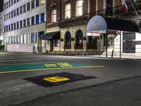 a city street with a few buildings and an umbrella on the corner at night,