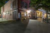 a cafe at night and a parked motor scooter in front of the building