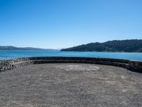 a bench that is on a large stone floor with mountains behind it in the background