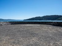 a bench that is on a large stone floor with mountains behind it in the background