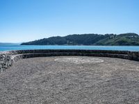 a bench that is on a large stone floor with mountains behind it in the background