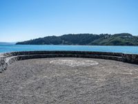 a bench that is on a large stone floor with mountains behind it in the background