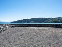 a bench that is on a large stone floor with mountains behind it in the background