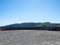 a bench that is on a large stone floor with mountains behind it in the background